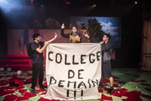 Jeunes comédiens brandissant une banderole dans leur salle de classe 