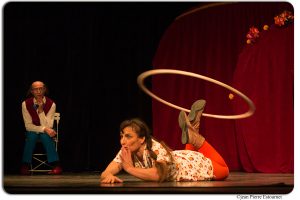 circassienne à plat ventre faisant du hulla hoop sur ses pieds 